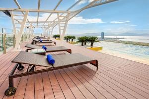 a deck with benches and a view of the beach at Luxury Studio Infinity Pool Golden Bay in Danang