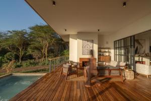 a house with a wooden deck and a swimming pool at Rubi Ranch Lakehouses in Naivasha