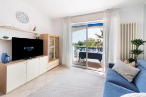 a living room with a tv and a blue couch at Casa Celeste Sea View - Riviera Collection in Misano Adriatico +26 photos
