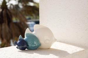 two ceramic fish figurines sitting on a wall at Casa Celeste Sea View - Riviera Collection in Misano Adriatico