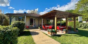 a house with a patio with red chairs and tables at Le Clos Nicolas in Eugénie-les-Bains +45 photos