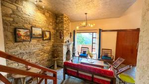 a living room with a stone wall at Natural Elements by Levitate - Premium Two Room Chalet with Private Terrace Panoramic Forest View & Dedicated Kitchen in Rāmgarh +20 photos