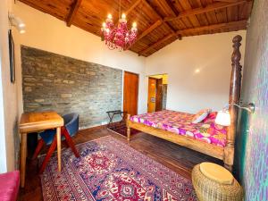 a bedroom with a bed and a table and a chandelier at Natural Elements by Levitate - Premium Two Room Chalet with Private Terrace Panoramic Forest View & Dedicated Kitchen in Rāmgarh