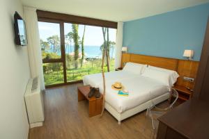 a bedroom with a bed with a view of the ocean at Hotel Alén do Mar in Finisterre