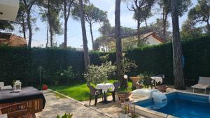 a backyard with a swimming pool with tables and chairs at Poolside and Garden Apartments Golem Beach in Golem