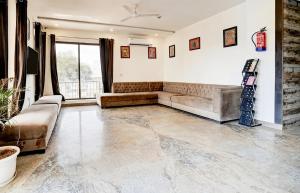 a living room with a couch and a television at GREAT ROYAL eMPIRE in Tājganj