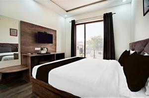 a bedroom with a large bed and a window at GREAT ROYAL eMPIRE in Tājganj
