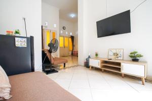 a living room with a couch and a television on a wall at Rayyan Homestay Jogja in Timuran