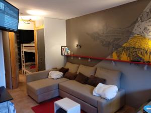 sala de estar con sofá y TV en Chalet Des Brigues en Courchevel