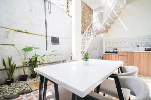 a white table and chairs in a room with plants at Rayyan Homestay Jogja in Timuran