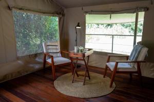 a room with a desk and two chairs and a table at Oreteti Mara Lodge in Lolgorien