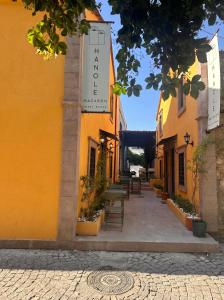 a yellow building with a sign on it at Hanole Macaron Guest House in Ayvalık