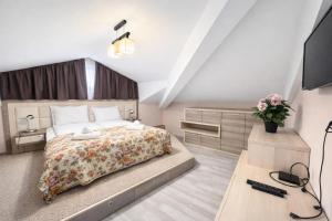 a bedroom with a bed and a desk and a television at Къщата с чешмата in Veliko Tŭrnovo