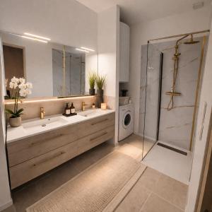 a bathroom with two sinks and a shower and a washing machine at Maison cosy proche plage in Elne