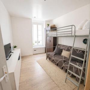 a bedroom with a bunk bed and a desk at Maison cosy proche plage in Elne