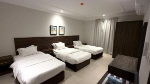 a hotel room with two beds and a couch at عوالي للشقق المخدومة Awali Serviced Apartments in Al Khobar