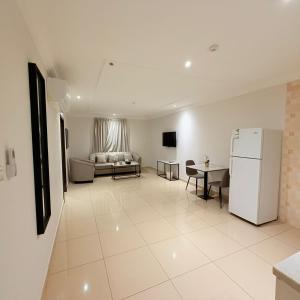 a living room with a refrigerator and a couch at عوالي للشقق المخدومة Awali Serviced Apartments in Al Khobar
