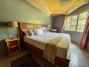 a bedroom with a large bed and a window at Oreteti Mara Lodge in Lolgorien