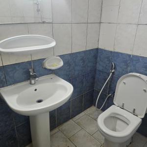a bathroom with a sink and a toilet at Bedroom with shared kitchen men only in Sharjah
