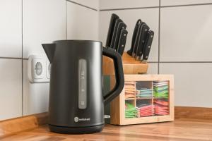a black coffee pot sitting on a counter next to knives at Salí Homes Weinblick Beethoven - ruhige Feldlage in Obersulm