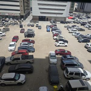 a parking lot full of cars in a city at Bedroom with shared kitchen men only in Sharjah