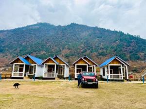 a man standing in front of a row of houses at Sangti River Front Homestay in Dirang Dzong