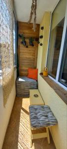 a small room with a bed and a bench and a window at Joy Home Varna in Varna City