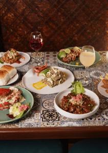 a table with plates of food and a glass of wine at Le Sparrow Beach- Rooms in Mangalore +15 photos