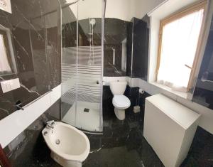 a black and white bathroom with a toilet and a sink at La mia casetta in Taormina +17 photos