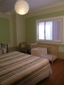a bedroom with two beds and a window and a crib at L'oleandra appartamenti in Lacona