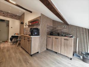 a kitchen with wooden cabinets and a sink and a table at UB Prenociste in Vranjska Banja