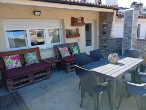 a patio with a table and chairs and a couch at Casona MilaWen in Potes
