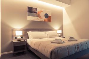 a bedroom with a bed with two lamps and a painting at Palazzo Digiuseppe Rooms in Martina Franca