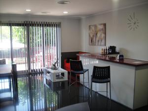 a kitchen with a bar with chairs and a table at Aparthotel El Faro in Cullera