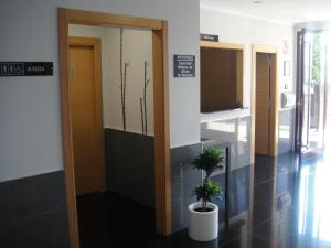a hallway with two potted plants in a building at Aparthotel El Faro in Cullera +37 photos