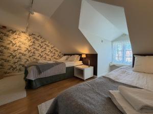 a attic bedroom with two beds and a window at Strandlogiet Ljugarn in Ljugarn