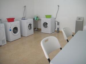 a room with four washing machines and a table and chairs at Aparthotel El Faro in Cullera