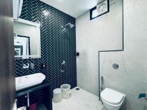 a bathroom with a toilet and a sink and a shower at HOTEL SUNIL INN in Raipur
