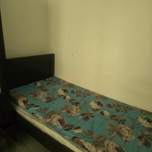 a bed with a blue comforter with flowers on it at Bedroom with shared kitchen men only in Sharjah