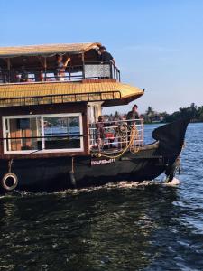 a boat with people on it in the water at Elagance Premium Houseboats in Alleppey +6 photos