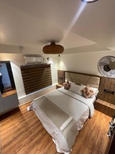 a bedroom with a white bed and a television at Elagance Premium Houseboats in Alleppey