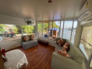 a living room with two couches and large windows at Elagance Premium Houseboats in Alleppey