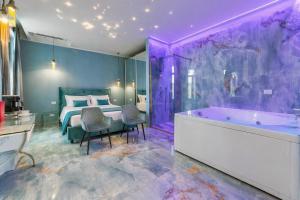a purple bedroom with a bed and a tub at Suite Acquamarine by Symphonya Luxury Holiday Rentals in Gallipoli