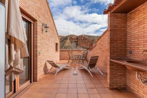 a patio with chairs and a table with a view at ATICO El TRANCO in Villel