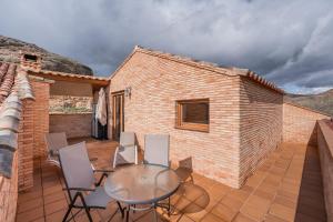 a patio with a table and chairs on a house at ATICO El TRANCO in Villel +6 photos