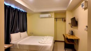 a room with a bed and a desk and a television at Shwe Ooe Lay Guest House 2 in Pratunam