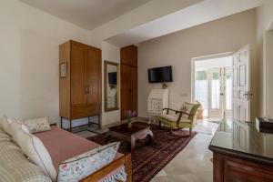 a living room with a couch and a tv at Barwara Kothi in Jaipur