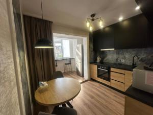 a kitchen with a wooden table and a small dining room at Sweethome Riscani in Chişinău