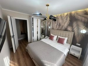 a bedroom with a large bed with two pink pillows at Sweethome Riscani in Chişinău