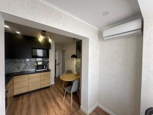 a kitchen and dining room with a table in a room at Sweethome Riscani in Chişinău +12 photos